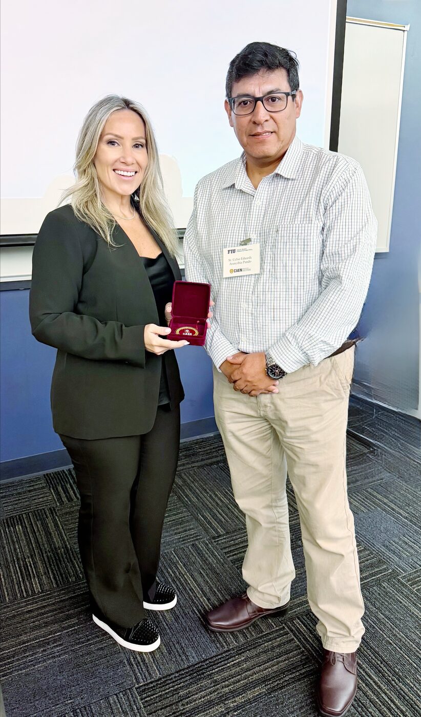 Jovianna Gonzalez receiving a commemorative medallion after presenting at Florida International University