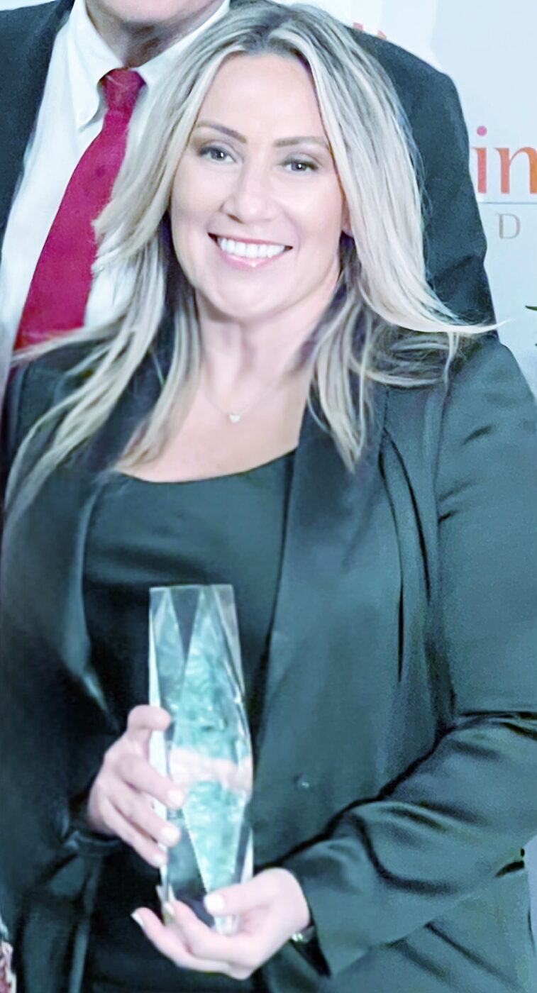 Jovianna Gonzalez holding an award at an industry recognition event