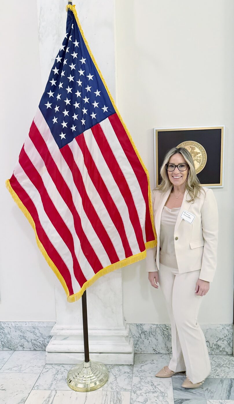 Jovianna Gonzalez beside the Great Seal of the State of Florida at a state government engagement