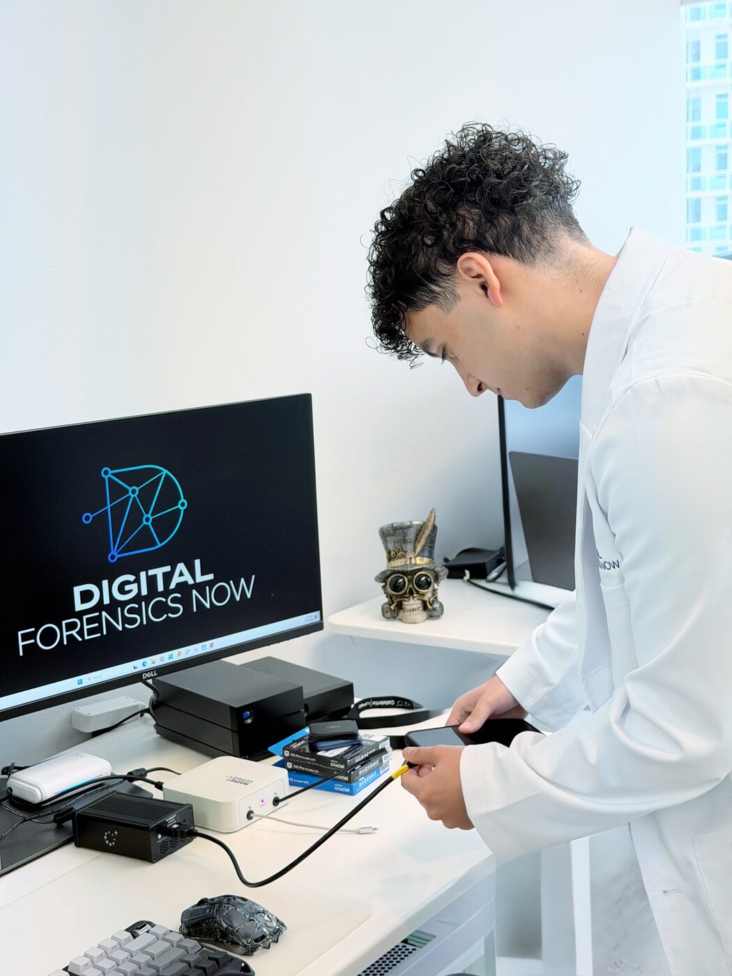 DFN analyst connecting a mobile device to acquisition hardware at a forensic imaging station